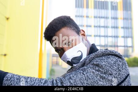 Ritratto di elegante giovane uomo che indossa la maschera facciale Foto Stock