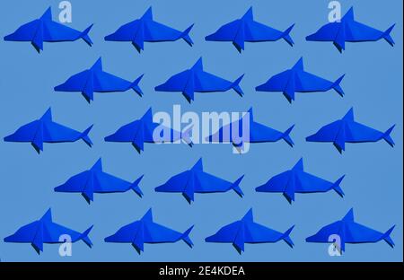 Origami di delfino blu disposti su sfondo colorato Foto Stock