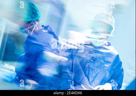 Chirurghi ortopedici maschi che eseguono interventi in terapia intensiva in ospedale Foto Stock