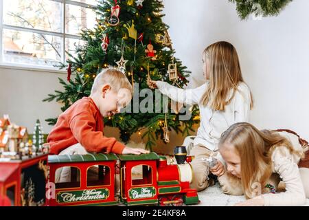 Fratelli che giocano con i giocattoli a casa durante il Natale Foto Stock