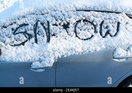 Un'auto sotto la neve. Neve e ghiaccio sulle auto dopo un'estrema nevicata in città. Scena cittadina invernale. L'auto sulla strada è coperta di pioggia di ghiaccio. Neve-c. Foto Stock