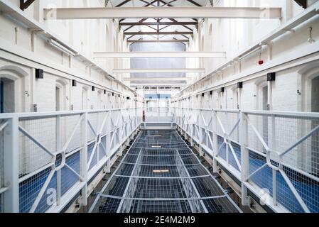 Guardando nella cella di prigione che atterra in carcere vittoriano inglese britannico casa letto in camera di chiusura in alto sicurezza camera derelict Vecchia nuova categoria A B C. Foto Stock