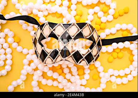 Maschera di Carnevale e ghirlande festive su uno sfondo luminoso. Immagine per una copertina o un poster. Il concetto di Carnevale di Venezia in italia. Foto di alta qualità Foto Stock