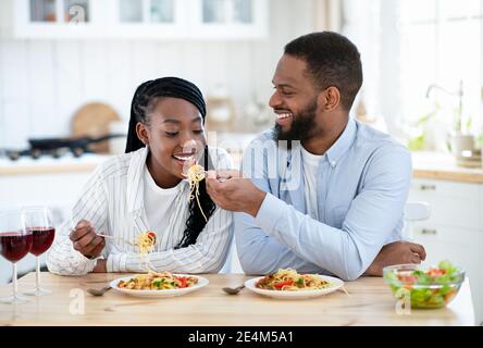 Bella coppia afroamericana con un pranzo romantico insieme in cucina Foto Stock