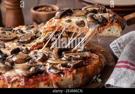 Primo piano di una fetta di pizza di funghi e formaggio una spatola da portata Foto Stock