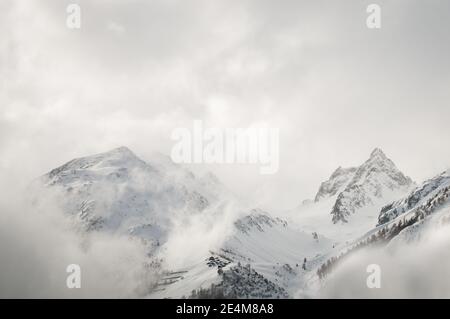 le cime innevate delle alpi svizzere sono circondate da nuvole e nebbia. Foto di alta qualità Foto Stock