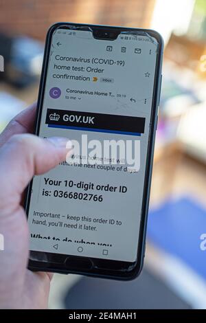 Utilizzando lo smartphone per ordinare il kit di test Coronavirus Covid-19 home su NHS , sito Web del servizio sanitario nazionale Foto Stock