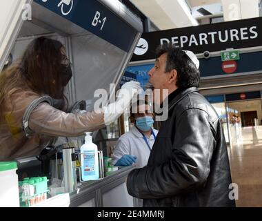 Lod, Israele. 24 gennaio 2021. Un lavoratore raccoglie un campione di tampone da un viaggiatore presso uno stand DI test CHECK 2 FLY Rapid coronavirus nell'aeroporto ben Gurion di Israele a Lod, vicino a Tel Aviv, domenica 24 gennaio 2021. Foto di Debbie Hill/UPI Credit: UPI/Alamy Live News Foto Stock