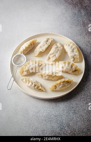 Gnocchi crudi asiatici su piastra bianca. Gnocchi dim sum cinesi tradizionali. Foto Stock