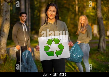 Donna volontaria sicura che detiene il simbolo di riciclaggio placard Foto Stock