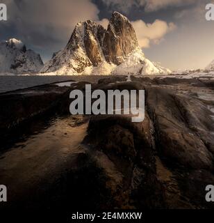 EPIC Hannoy picchi durante un freddo alba invernale, riflessa in piscine ghiacciate, Lofoten, Norvegia Foto Stock