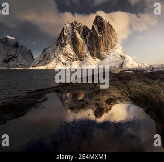 EPIC Hannoy picchi durante un freddo alba invernale, riflessa in piscine ghiacciate, Lofoten, Norvegia Foto Stock