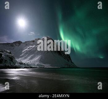 Aurora boreale / Aurora borealis e Luna a Storsandnessanden, Lofoten, Norvegia, di notte in inverno. Foto Stock