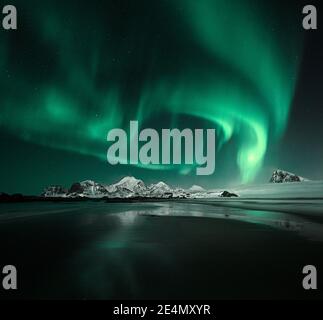 Aurora boreale / Aurora borealis a Storsandnessanden, Lofoten, Norvegia, di notte in inverno, riflessa in acqua. Foto Stock