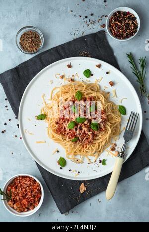 Bolognese di pasta italiana con basilico e noci su fondo grigio. Foto Stock