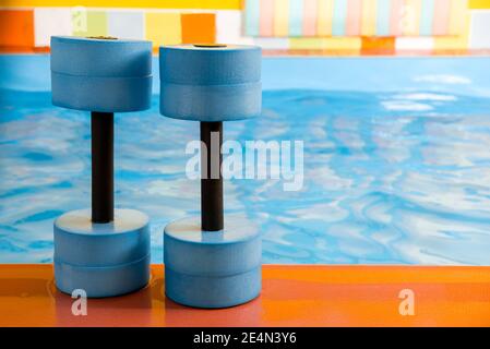 attrezzature per manubri per aerobica in acqua vicino alla piscina Foto Stock