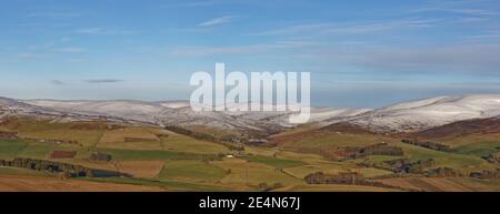 Un paesaggio Scozzese dei Glens Angus guardando verso Glen Esk, con neve sulle cime delle colline sopra le Farms sulle pendici inferiori. Foto Stock