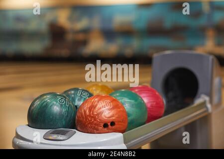 Immagine di sfondo di diverse palline da bowling su rack nel centro bowling, spazio copia Foto Stock