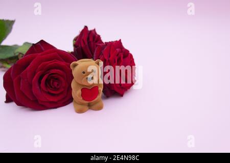 Cartolina per la vacanza, rose rosse e una scatola per un anello, orso Teddy Foto Stock