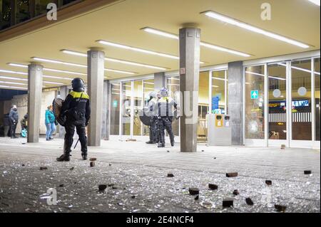 EINDHOVEN, PAESI BASSI - 24 GENNAIO: La polizia di Riot è vista vicino alla stazione centrale di Eindhoven il 24 gennaio 2021 a Eindhoven, Paesi Bassi dopo una protesta proibita contro le misure del coronavirus trasformate in rivolte. La polizia ha sgombrato la zona in e intorno alla stazione centrale dopo che i rioters hanno saccheggiato un supermercato e hanno messo il fuoco ad un automobile. (Foto di Joris Verwijst/BSR Agency/Alamy Live News) Foto Stock