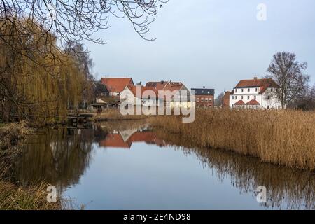 Mulino stagno e vecchie case con riflessione nella piccola città Rehna in Meclemburgo-Vorpommern, Germania settentrionale, copia spazio Foto Stock