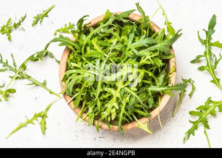 Rucola foglie verdi fresche a tavola bianca. Foto Stock