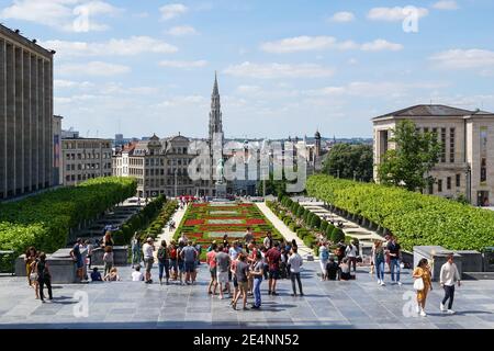 Le persone che godono di vista sul giardino del Mont des Arts con la guglia del municipio sullo sfondo a Bruxelles, Belgio Foto Stock