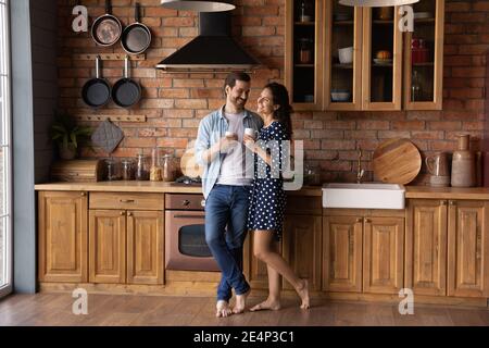 Happy couple Godetevi la mattina in un'accogliente cucina casalinga Foto Stock