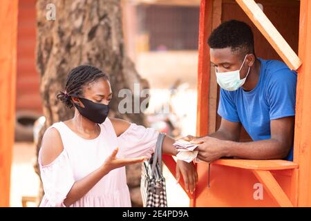 signora nigeriana che utilizza un servizio di prelievo pos per prelevare contanti Foto Stock