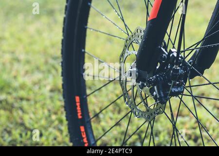 Vista ravvicinata del disco freno di una ruota anteriore per bicicletta. Foto Stock