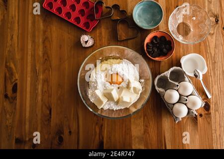 Mescolare il lievito in polvere nell'impasto delle uova per preparare i biscotti per torte. Foto Stock