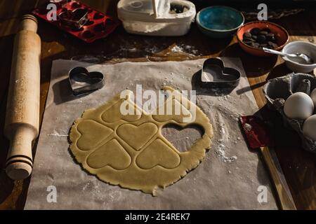 Fare biscotti cuore con una muffa di pasta cruda. Biscotti romantici muffe. Foto Stock