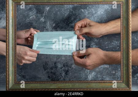 Lotta femminile e maschile sulla maschera medica in cornice Foto Stock