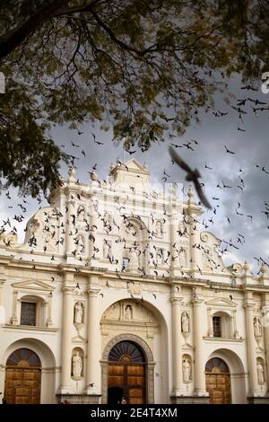 Piccioni che volano fuori dalla cattedrale di Antigua, Guatemala, America Centrale Foto Stock