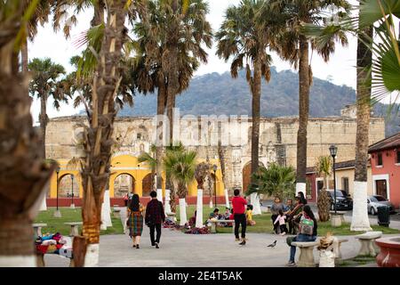 Le rovine di un convento spagnolo coloniale-orecchio sono lo sfondo di un parco pubblico ad Antigua, Guatemala, America Centrale. Foto Stock