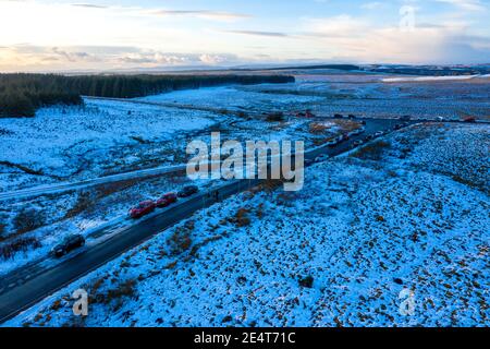 Whitelee Windfarm, Scozia, Regno Unito. 24 gennaio 2021. Nella foto: La gente fuori nelle loro masse godendo la giornata d'inverno frizzante al Windfarm Whitelee durante il blocco di fase 4. La polizia scozzese ha fornito consigli sulle persone in modo sensato, tuttavia ci sono masse di auto parcheggiate in tutto il luogo, nella misura in cui le auto sono state parcheggiate sul lato della strada, poiché è così occupato. Credit: Colin Fisher/Alamy Live News Foto Stock