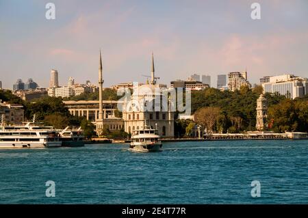 Vista sulla riva dello stretto di Bosforo con barca turistica Partenza dal terminal dei traghetti di Kabatas di fronte alla Moschea Dolmabahce Nel quartiere Beyoglu di Foto Stock