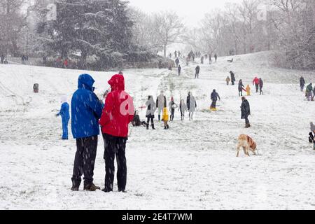 le persone che slittano sul pendio del parco greenwich si divertono Con neve a Londra Foto Stock