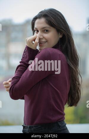 Giovane ragazza sorridente in posa sulla terrazza Foto Stock