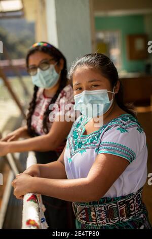 Giovani donne che indossano maschere protettive a San Juan la Laguna, Guatemala, America Centrale. Foto Stock