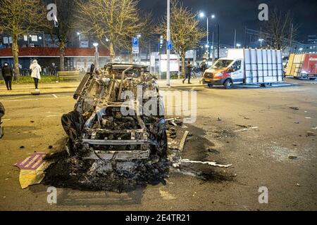 Dopo la dimostrazione, un'auto del ProRail è bruciata di fronte alla stazione ferroviaria centrale di Eindhoven. Detriti sulle strade di Eindhoven, il seguito di una manifestazione contro il nuovo Coronavirus Covid19 misure di copertura dopo il blocco. Gli scontri tra i manifestanti e gli agenti di polizia hanno portato alla combustione di un'auto, alla rottura delle finestre, al lancio di pietre e alla messa a punto di blocchi stradali con biciclette in fiamme, mentre la stazione ferroviaria centrale è stata danneggiata. La polizia ha fatto 55 arresti. Il coprifuoco è stato imposto tra le 21:00 e le 04:30 ora locale. Foto Stock