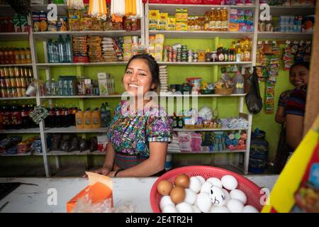 Lavoratore di negozio femminile a San Marcos la Laguna, Guatemala, America Centrale. Foto Stock