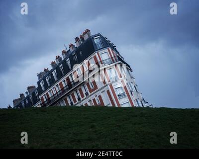 Vista panoramica illusione ottica di storico vecchio edificio affondato casa a verde erba collina Montmartre Parigi Francia, Europa Foto Stock