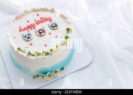 Torta di compleanno minimale e decorato cute viso gatto e fiore piccolo sulla parte superiore con bianco tessuto di fondo. Dessert tailandese Foto Stock