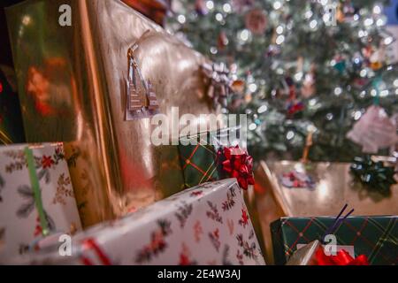 Regali di Natale con tag regalo - pila di Natale - avvolto Regali - presenti con l'etichetta regalo sotto un albero di Natale - Decorazioni e archi di Natale Foto Stock