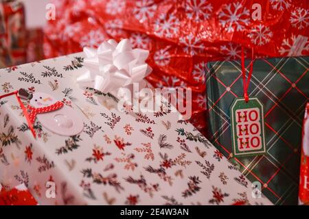 Regali di Natale con tag regalo - pila di Natale - avvolto Regali - presenti con l'etichetta regalo sotto un albero di Natale - Decorazioni e archi di Natale Foto Stock