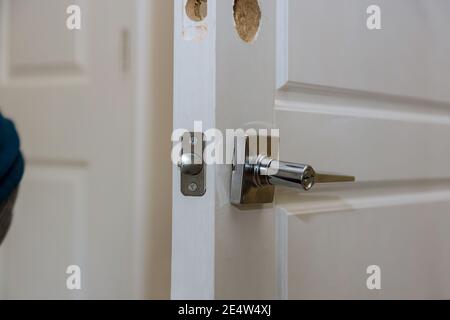 Installazione del nuovo armadietto per le mani del lavoratore nella serratura della portiera Foto Stock