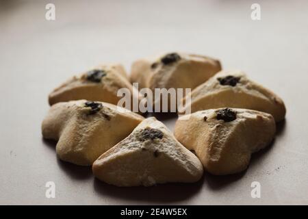 Ozney haman (orecchio di Haman) pasta Triangolare fatta di pasta croccante farcita. Cibo ebraico tradizionale per Purim. Situato su una superficie di legno Foto Stock