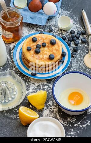 Pancake americani e ingredienti su sfondo ardesia Foto Stock
