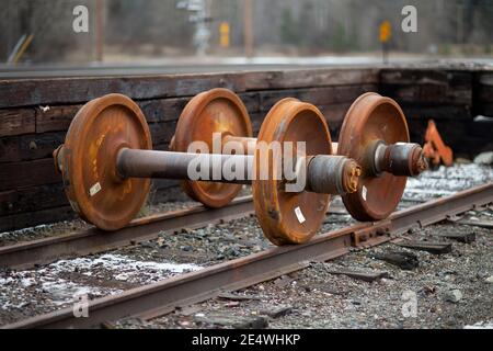 Ruote e assale di ricambio per autocarri ferroviari sui cingoli, presso il cantiere ferroviario BNSF, Troy, Montana. Burlington Northern e Santa Fe Railway erano per Foto Stock